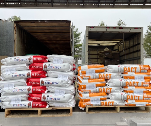 Livestock feed and supplies being loaded into delivery trucks